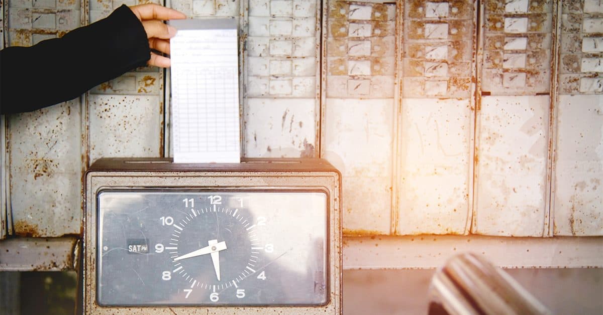 Person punching a time card in an old-school time clock.